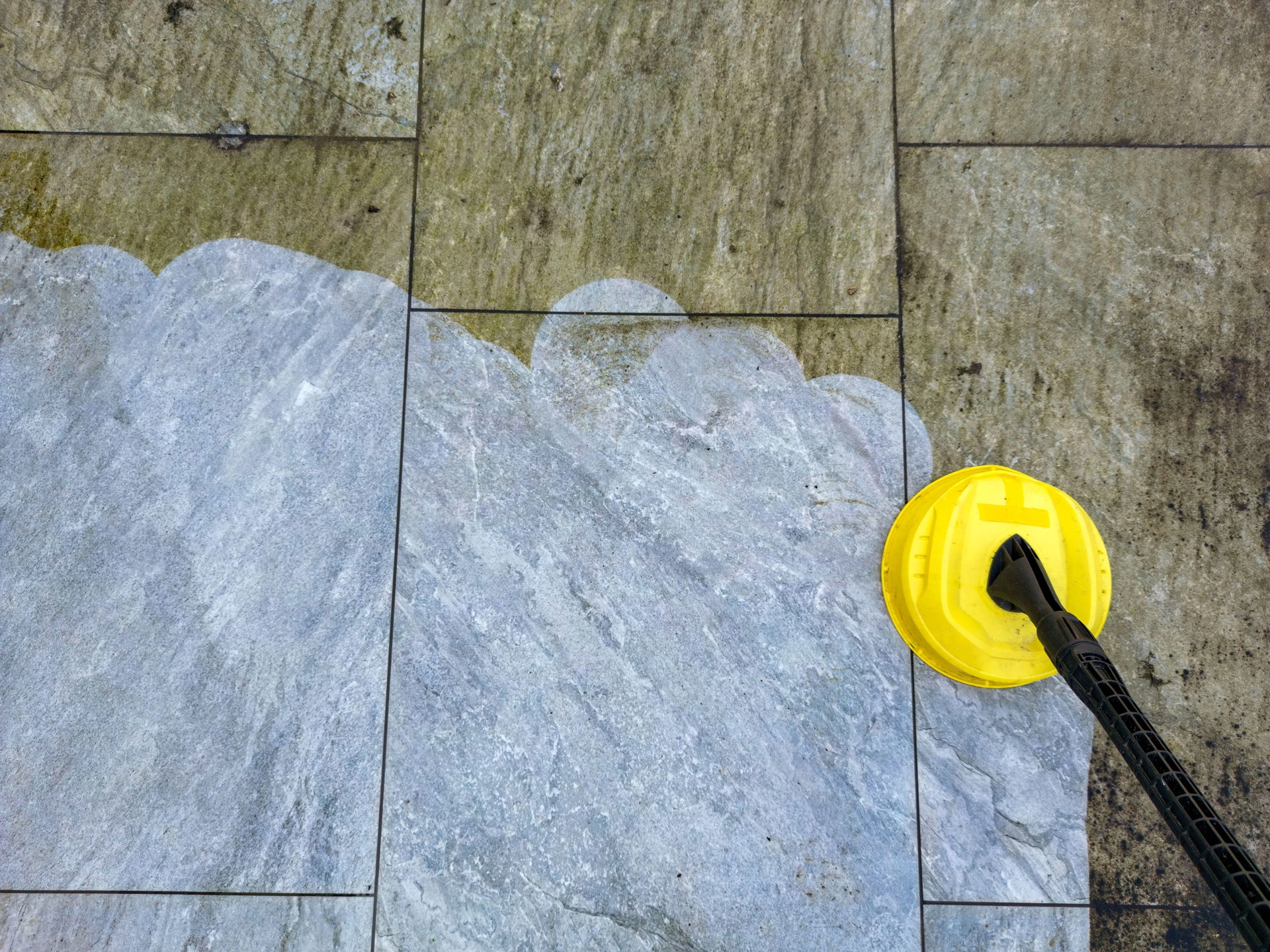 Pressure washer cleaning a garden patio