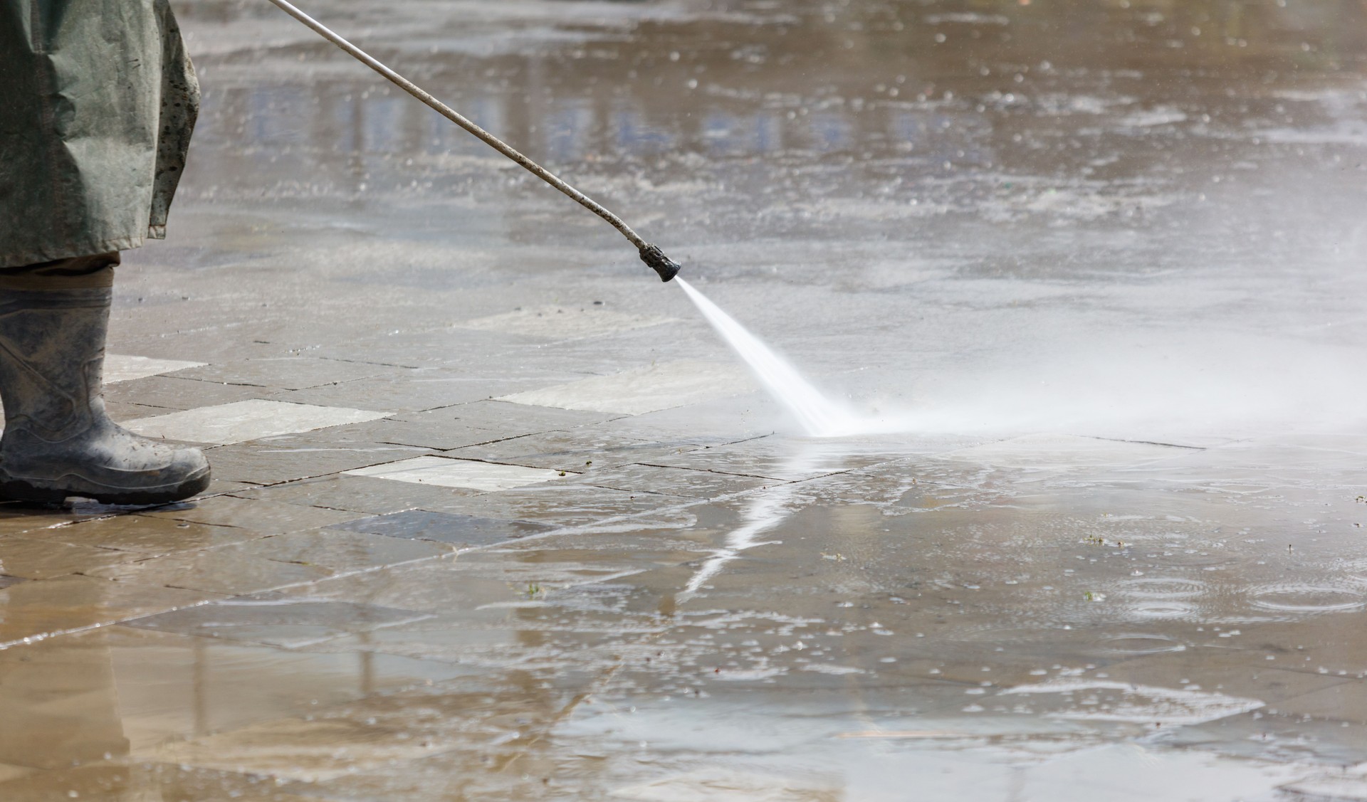 A hose is spraying water on a sidewalk